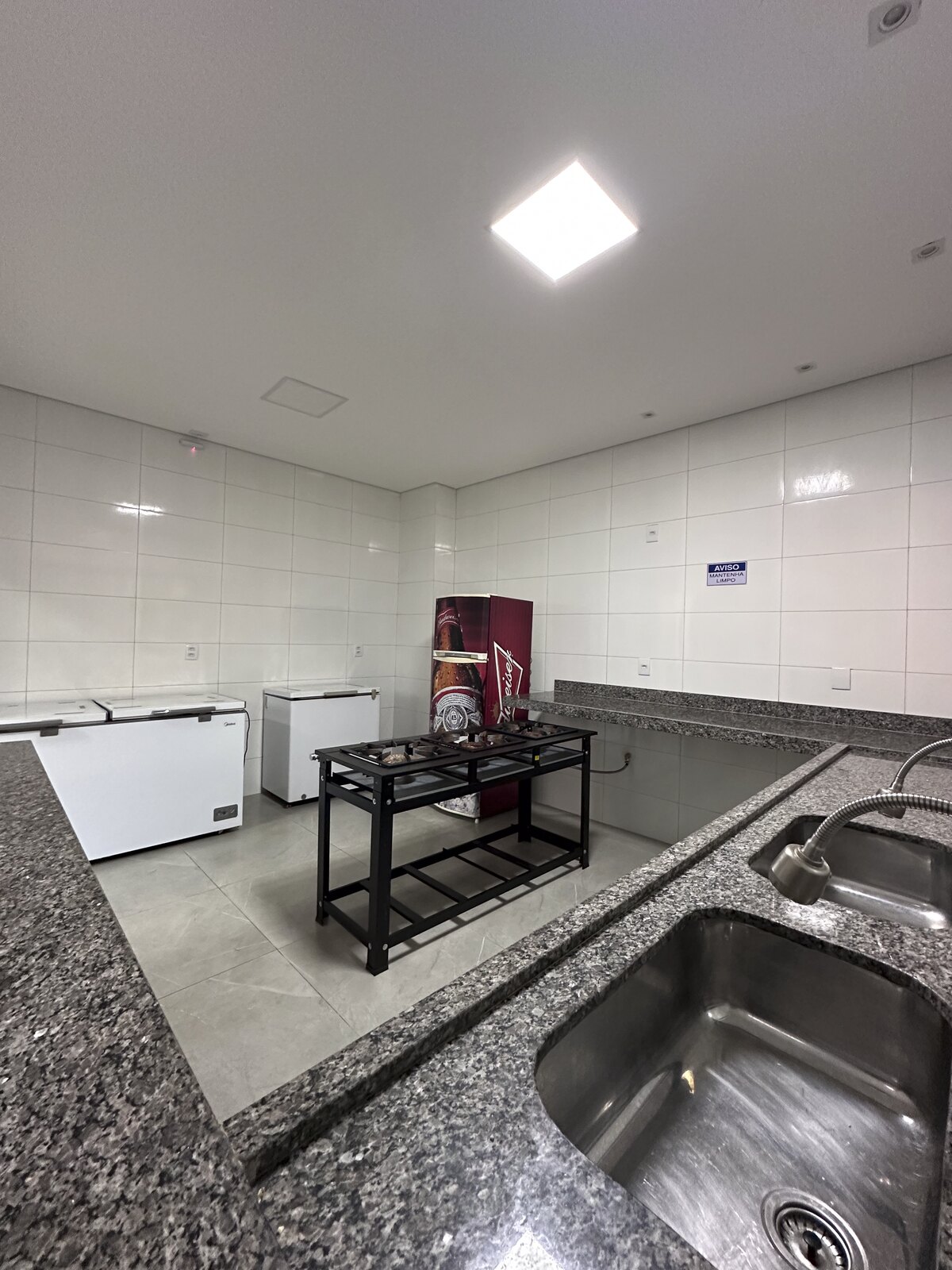 Bancada de granito com cuba e freezer na cozinha da Dream House Eventos