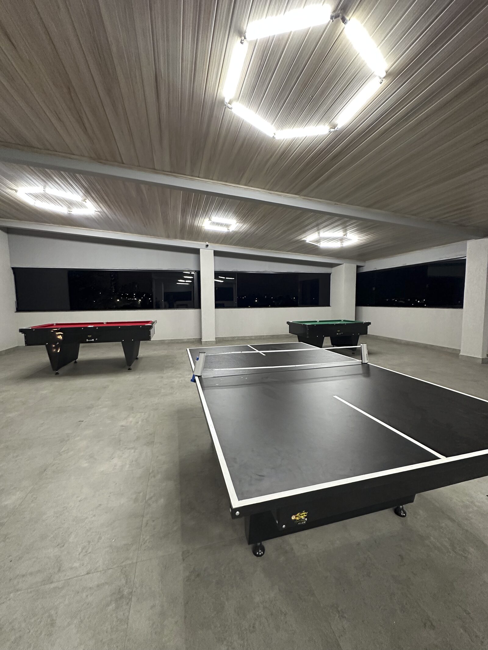 Sala de jogos do terceiro piso da Dream House com mesas de sinuca e ping-pong