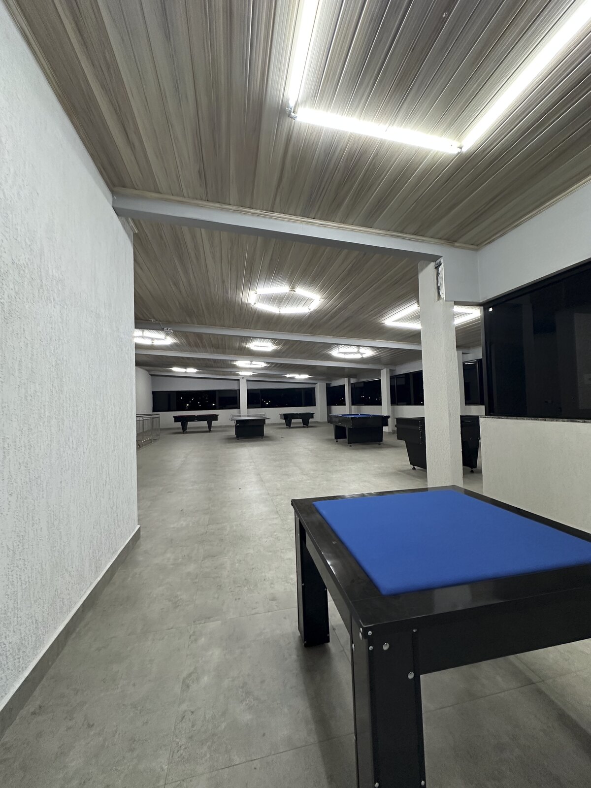 Sala de jogos do terceiro piso com mesa azul
