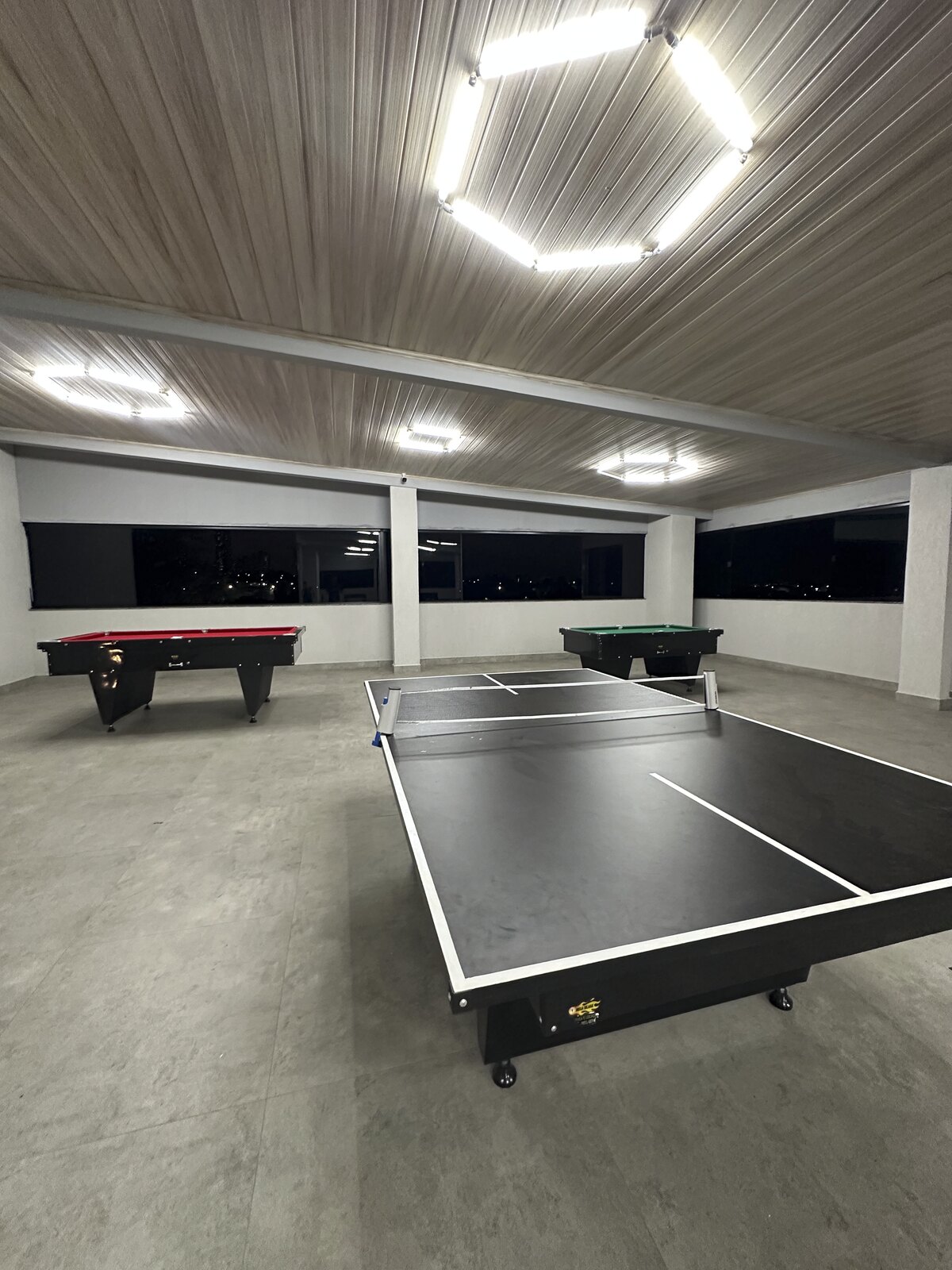 Sala de jogos do terceiro piso com mesa de ping-pong e sinuca