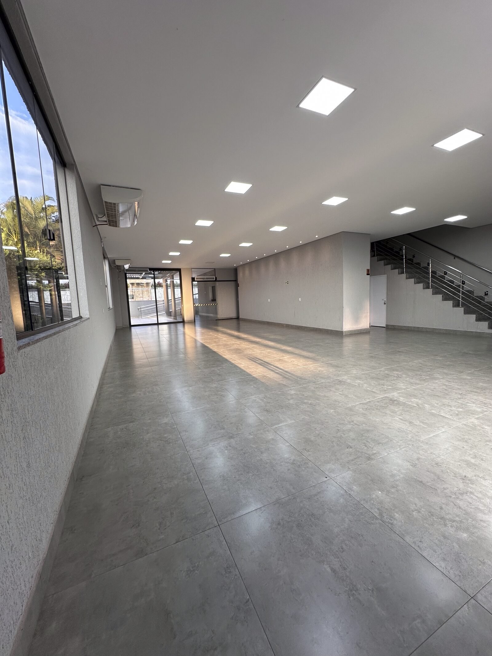 Salão climatizado do primeiro piso da Dream House Eventos em Goiânia, com piso porcelanato, iluminação em LED e acesso para a área da piscina